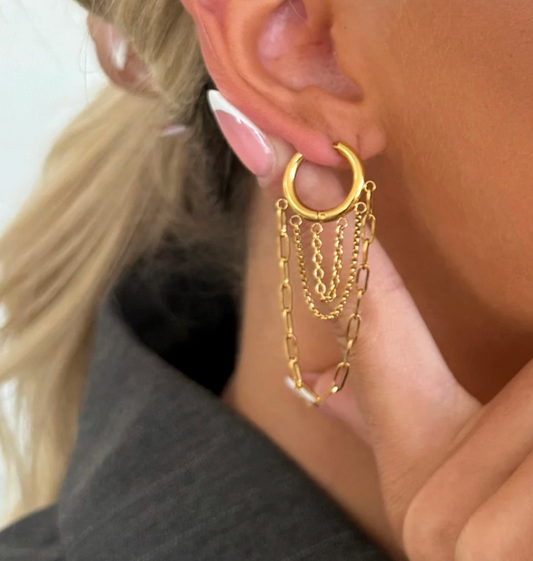 Gold hoop earring with chain details worn by a person