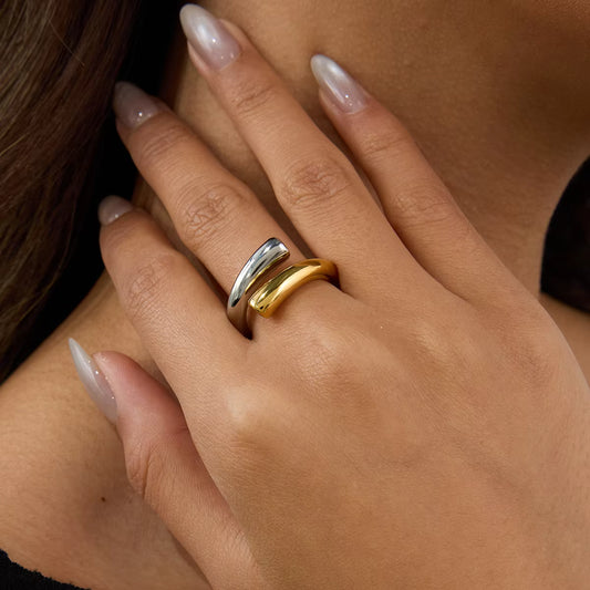 Close-up of a hand wearing two rings with a neutral background