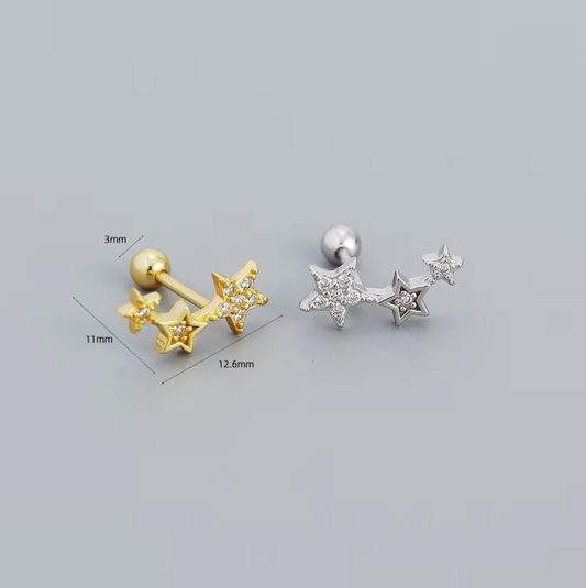 Gold and silver star-shaped earrings with measurements on a gray background