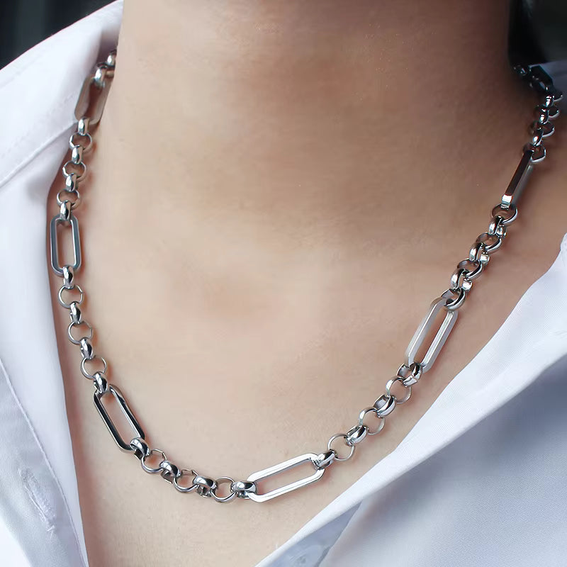 Silver chain necklace worn by a person with a blurred background
