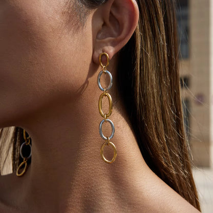 Close-up of a woman wearing gold and silver chain earrings.