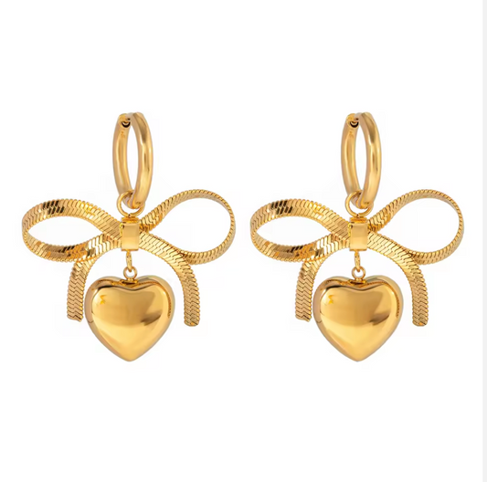 Gold bow and heart earrings on a white background