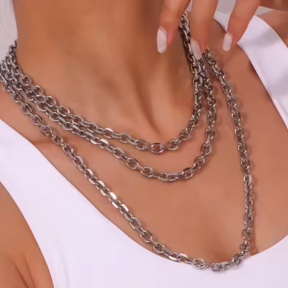 This image highlights the Pedro Necklace, showcasing its elegant and layered design. The necklace features multiple chains with a sleek, metallic finish, elegantly draping over the torso to create a sophisticated and chic appearance.