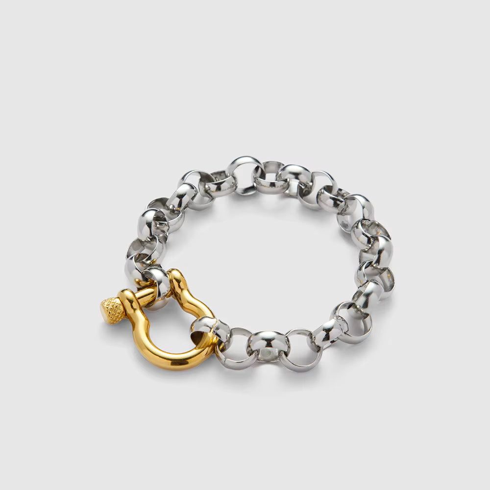 Silver chain bracelet with a gold clasp on a light gray background