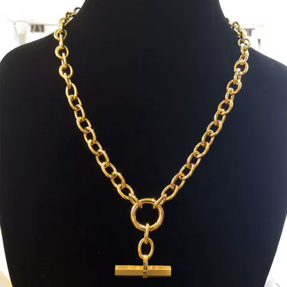 Gold chain necklace with a pendant on a black mannequin