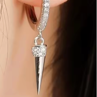 Silver earring with a spike design worn by a person