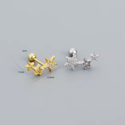 Gold and silver star-shaped earrings with measurements on a gray background
