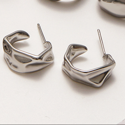 Silver geometric hoop earrings on a white background