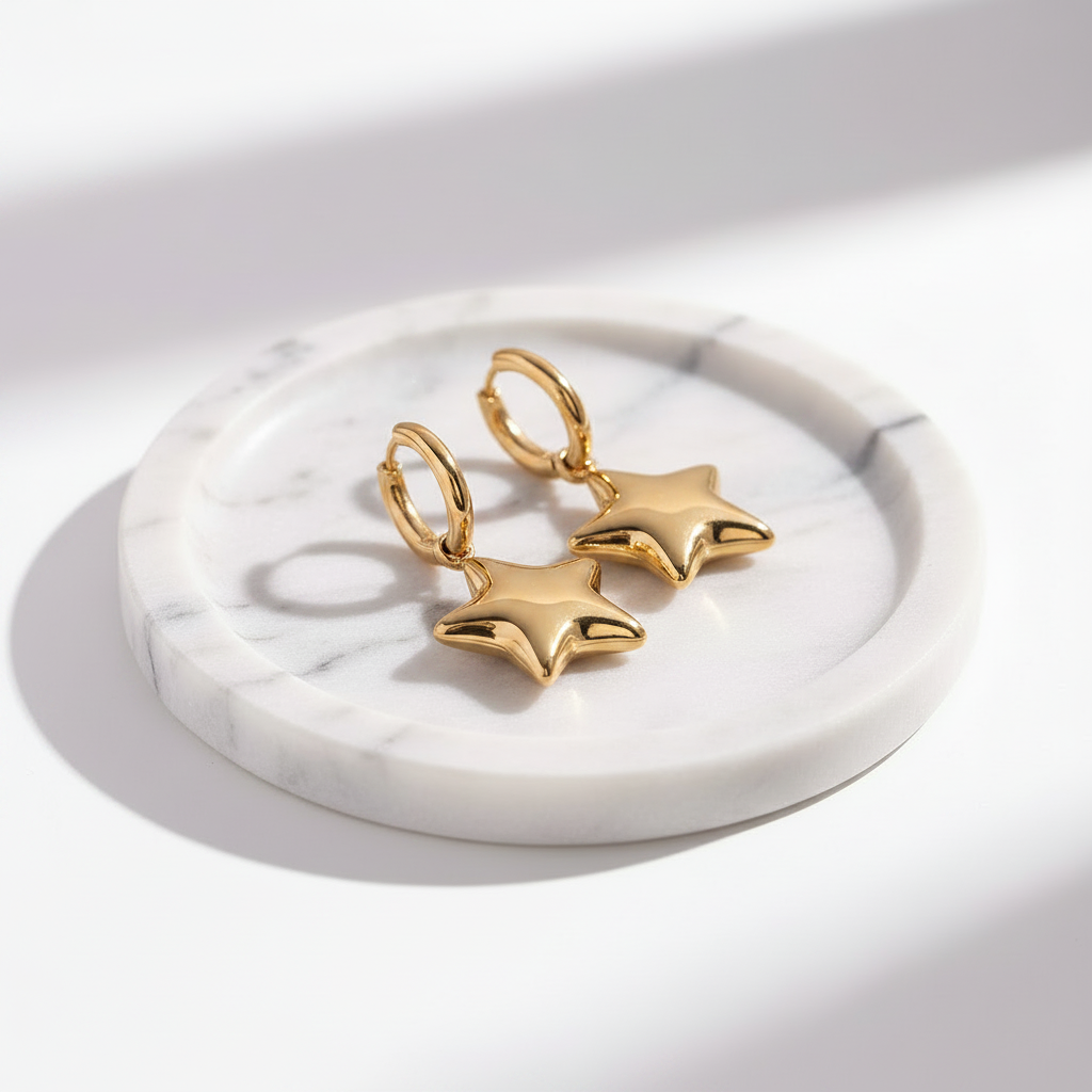 gold star-shaped earrings on a marble surface